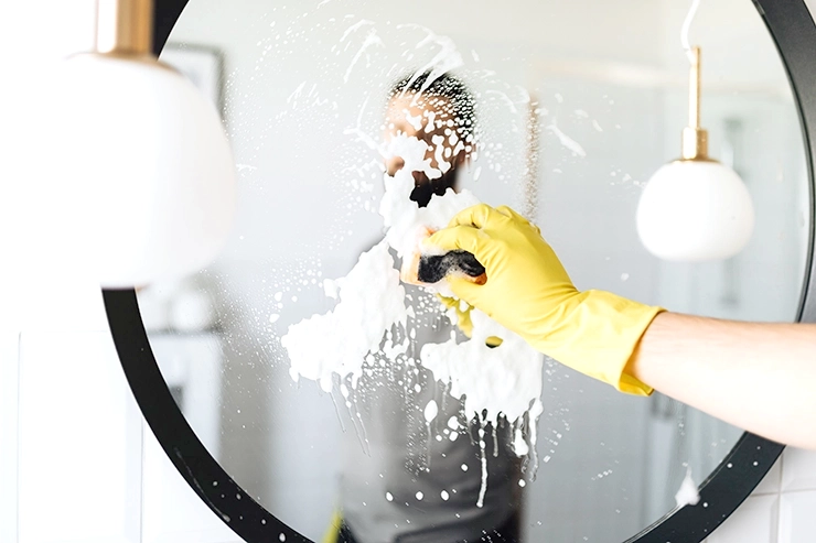 Homme nettoyant un miroir